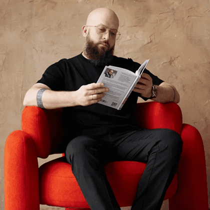 Доктор Коробов читает книгу в кресле